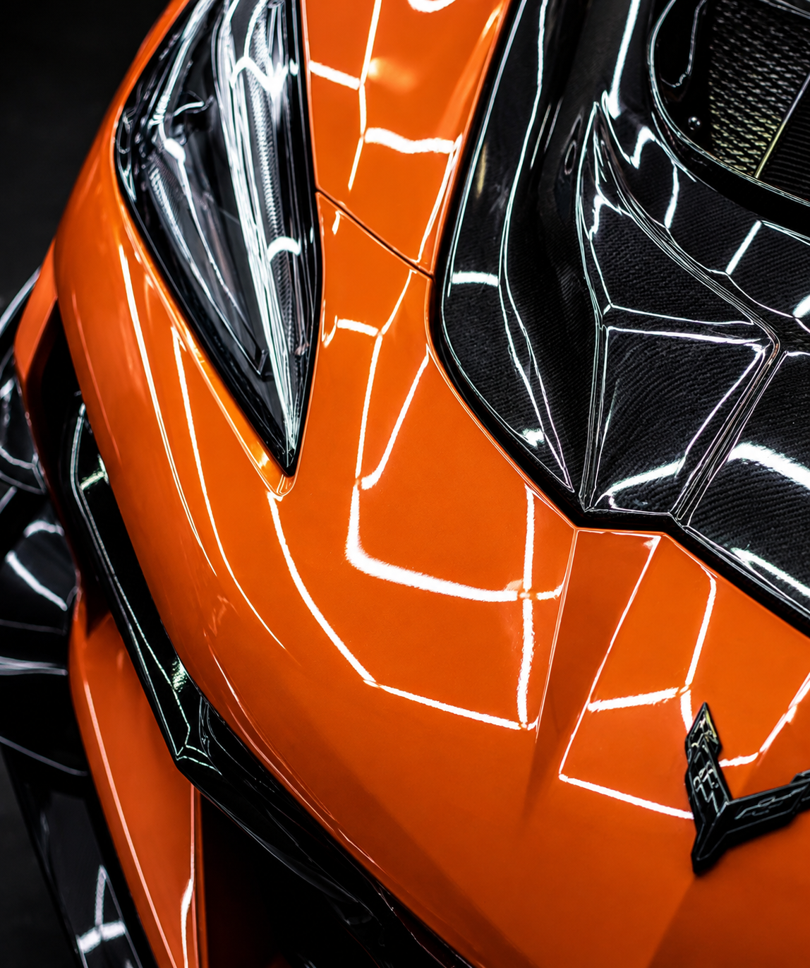 Orange Chevrolet Corvette with glossy paint and carbon fiber accents detailed at CustomsByAli in Elyria, OH