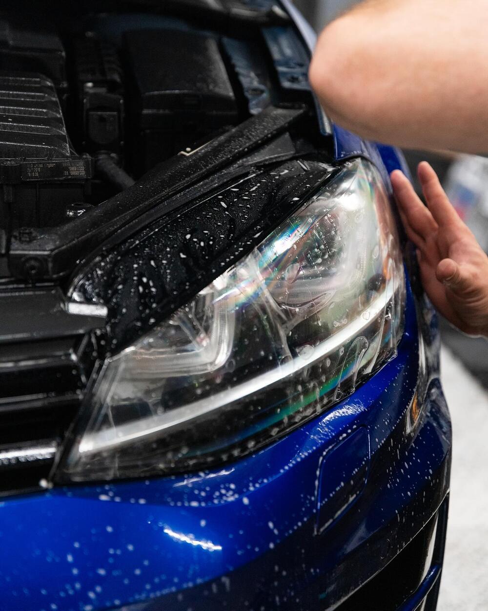 Close-up of clear paint protection film being installed on a headlight at CustomsByAli in Elyria, OH