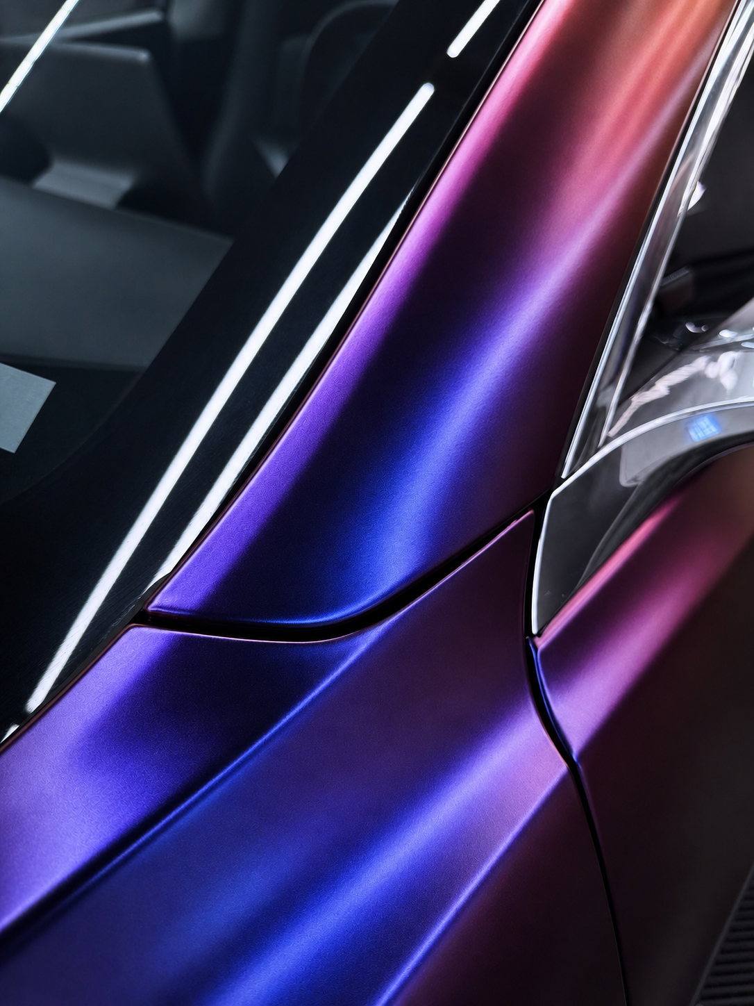 Close-up of a satin purple color shift wrap on a Tesla body panel